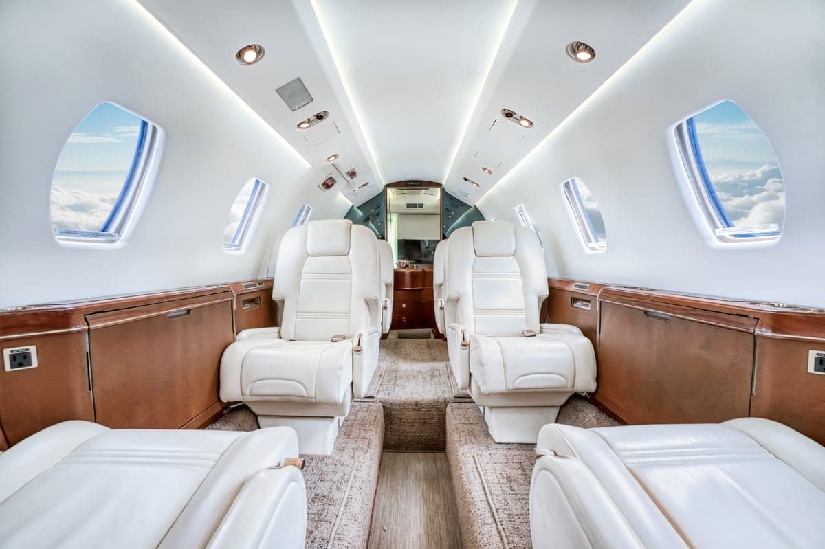 View of the interior cabin of a Cessna Citation CJ3+ with white leather seats.