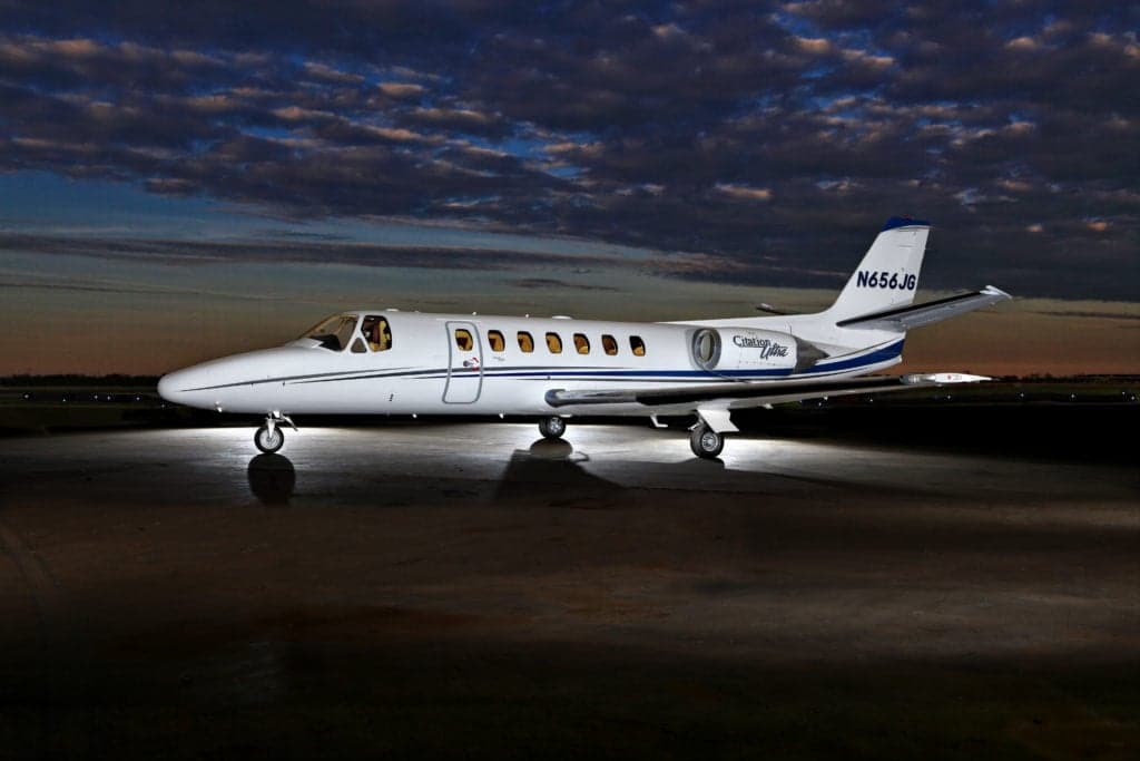 A Citation Ultra aircraft, tail number N656JG, is parked on the tarmac at dusk.