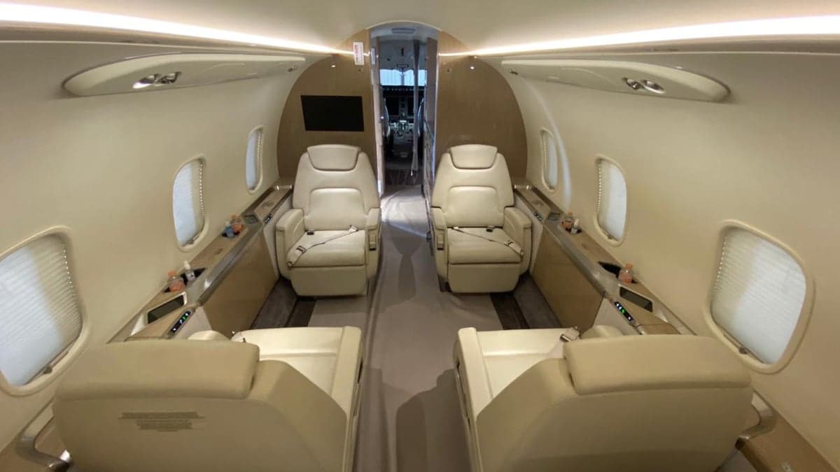 View of the aircraft cabin with cream-colored leather seats.