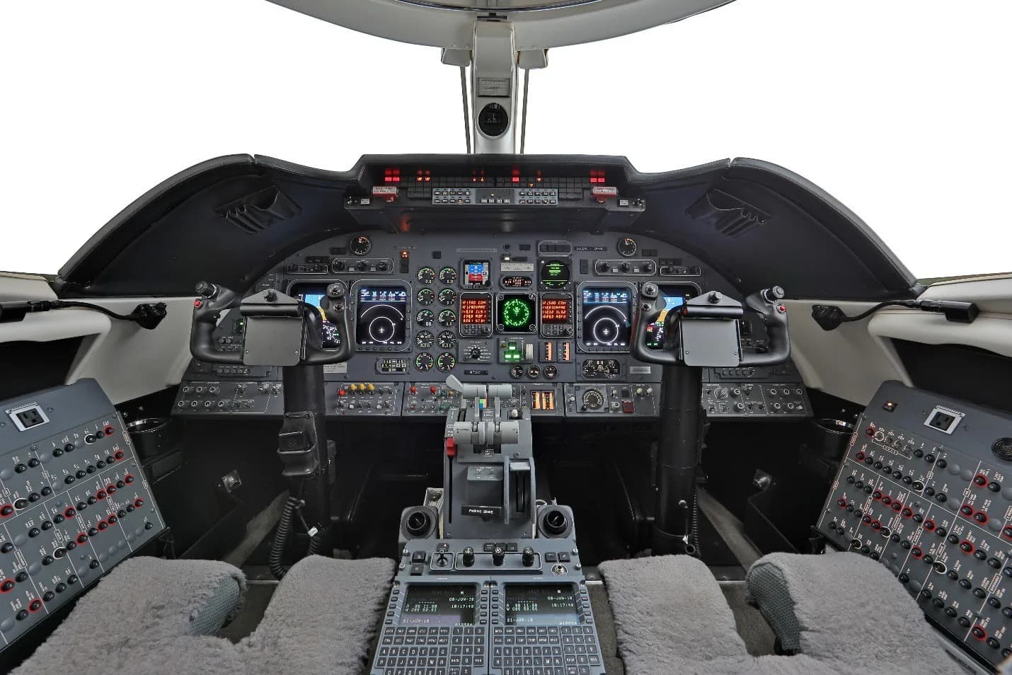 The cockpit of a business jet, featuring multiple display screens, control yokes, and a central throttle quadrant.