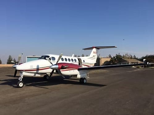 King Air 200 with door open on the tarmac.