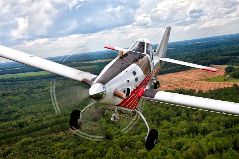 Air Tractor 702 in flight over a forest.