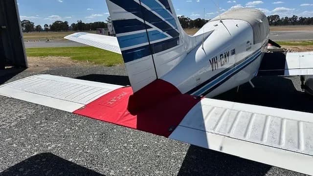 Close up of the tail of a white and blue aircraft with the registration VH-BAV.