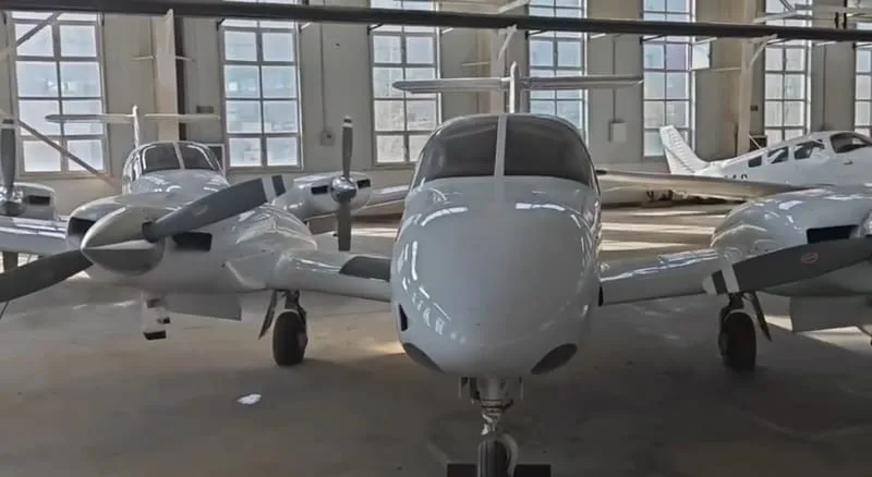 Close-up of a white twin-engine aircraft in a hangar.