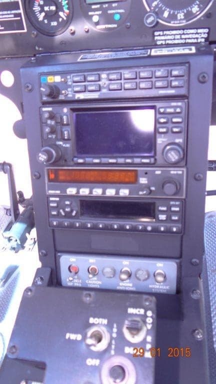 A close-up view of the avionics stack in a helicopter cockpit, showing radios and control panels.