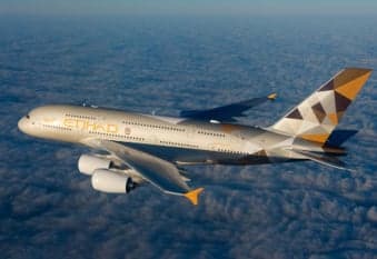 An Etihad Airbus A380 flying above the clouds.