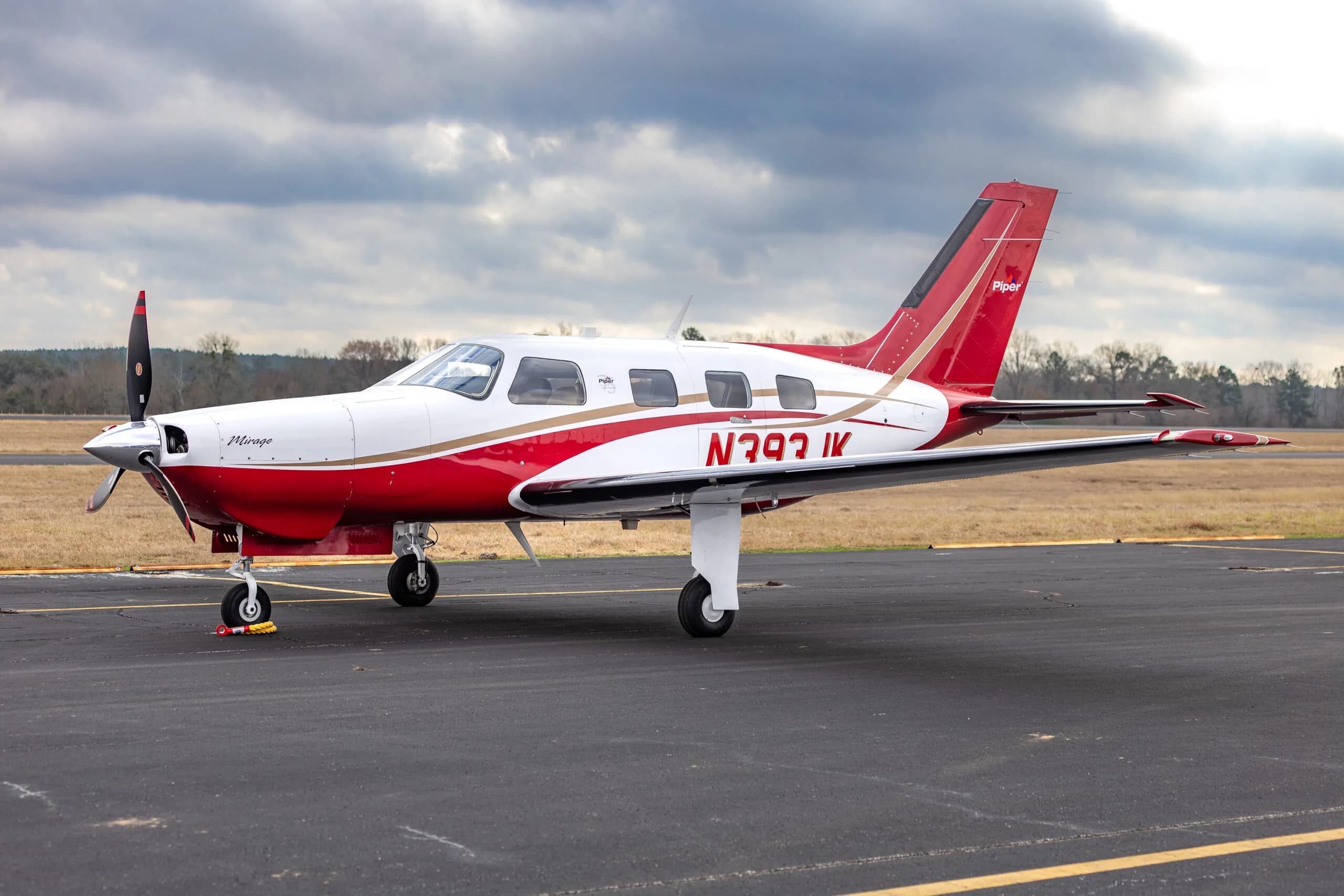 Piper Mirage N393JK parked on the tarmac with a red and white paint scheme.