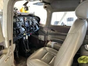 View of the Cessna 172 Skyhawk cockpit from the side, showing the instrument panel and pilot seat.