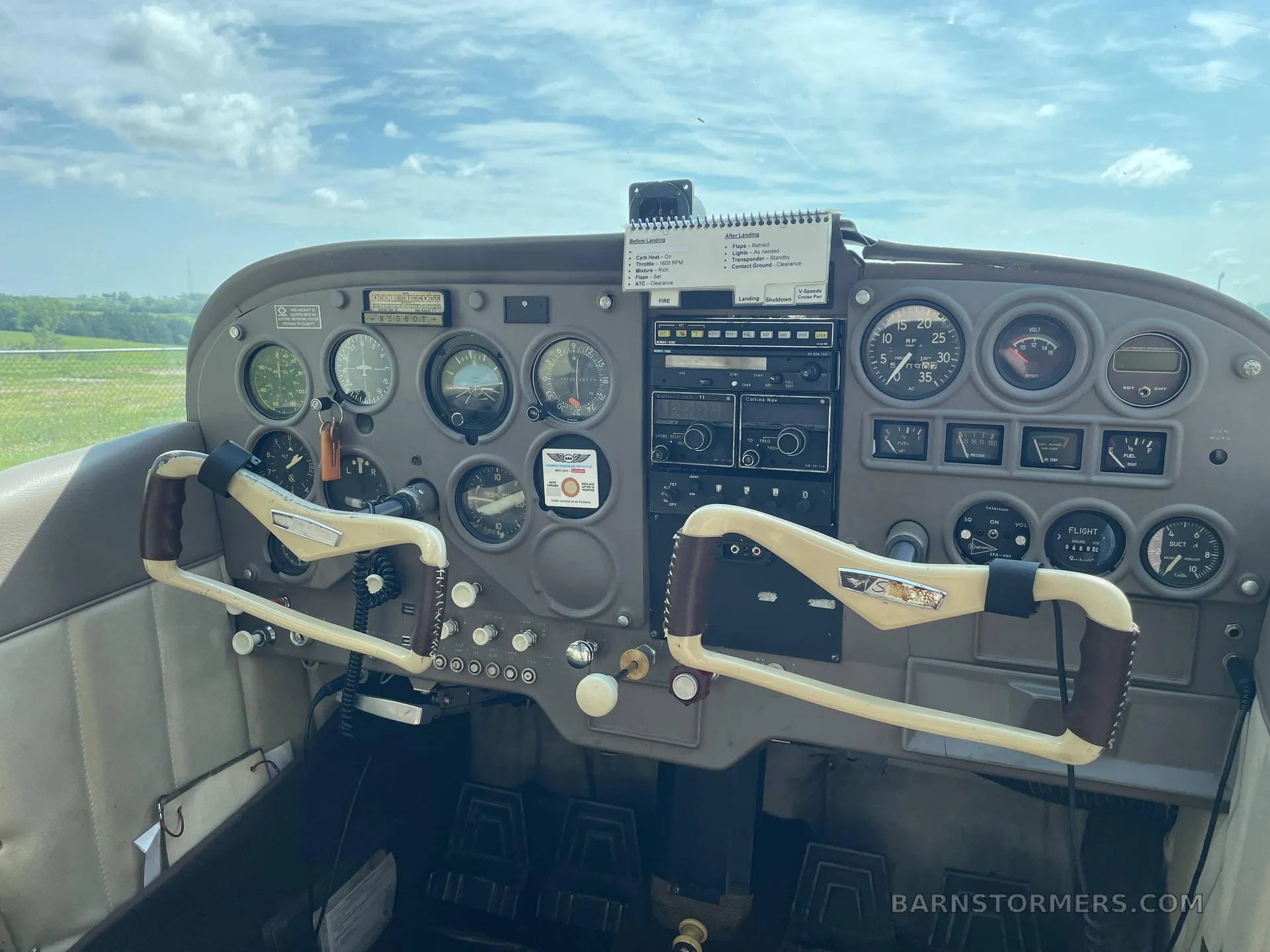 The cockpit of a Cessna aircraft, showing the instrument panel, yokes, and various controls.