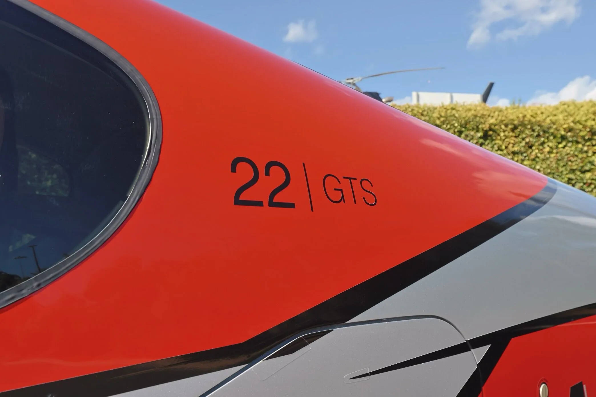 A close-up of the "22 GTS" and "CARBON" markings on the red and silver fuselage of the aircraft.