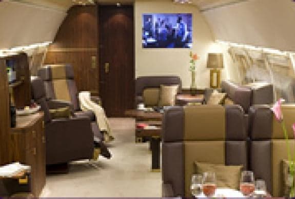 A luxurious aircraft interior with leather seats and a TV.