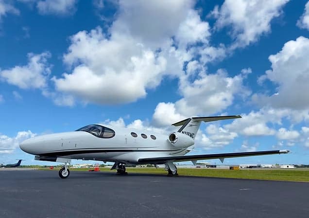 Phenom 300E aircraft with registration N95TG on the tarmac.