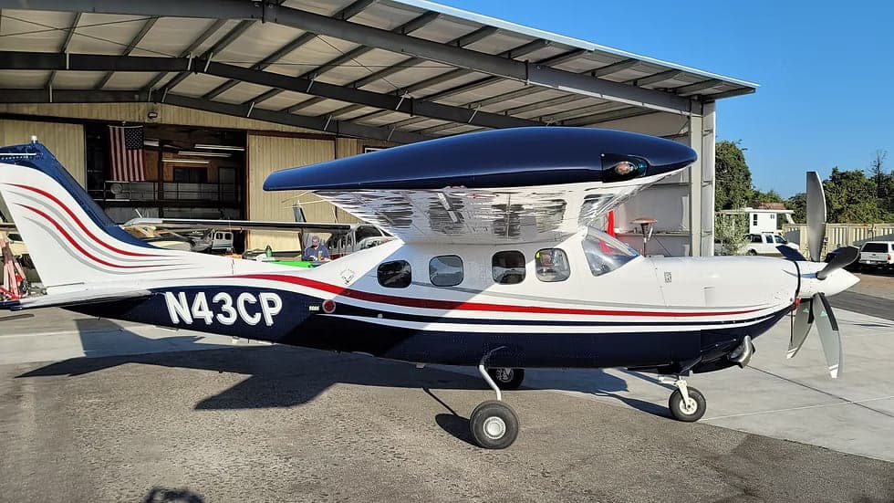A side view of the N43CP aircraft with a blue and white paint scheme.