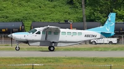 A Cessna Caravan aircraft with a blue and white paint scheme parked on the tarmac.