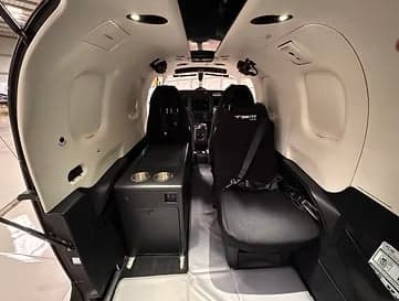 Interior view of the Pilatus PC-12 cabin showing seating and amenities.