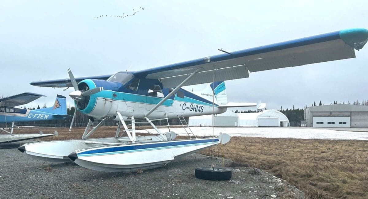 De Havilland DHC-2 Beaver floatplane in white and blue livery, parked on the ground.