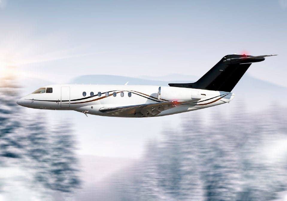 A Hawker jet in flight over a snowy landscape.