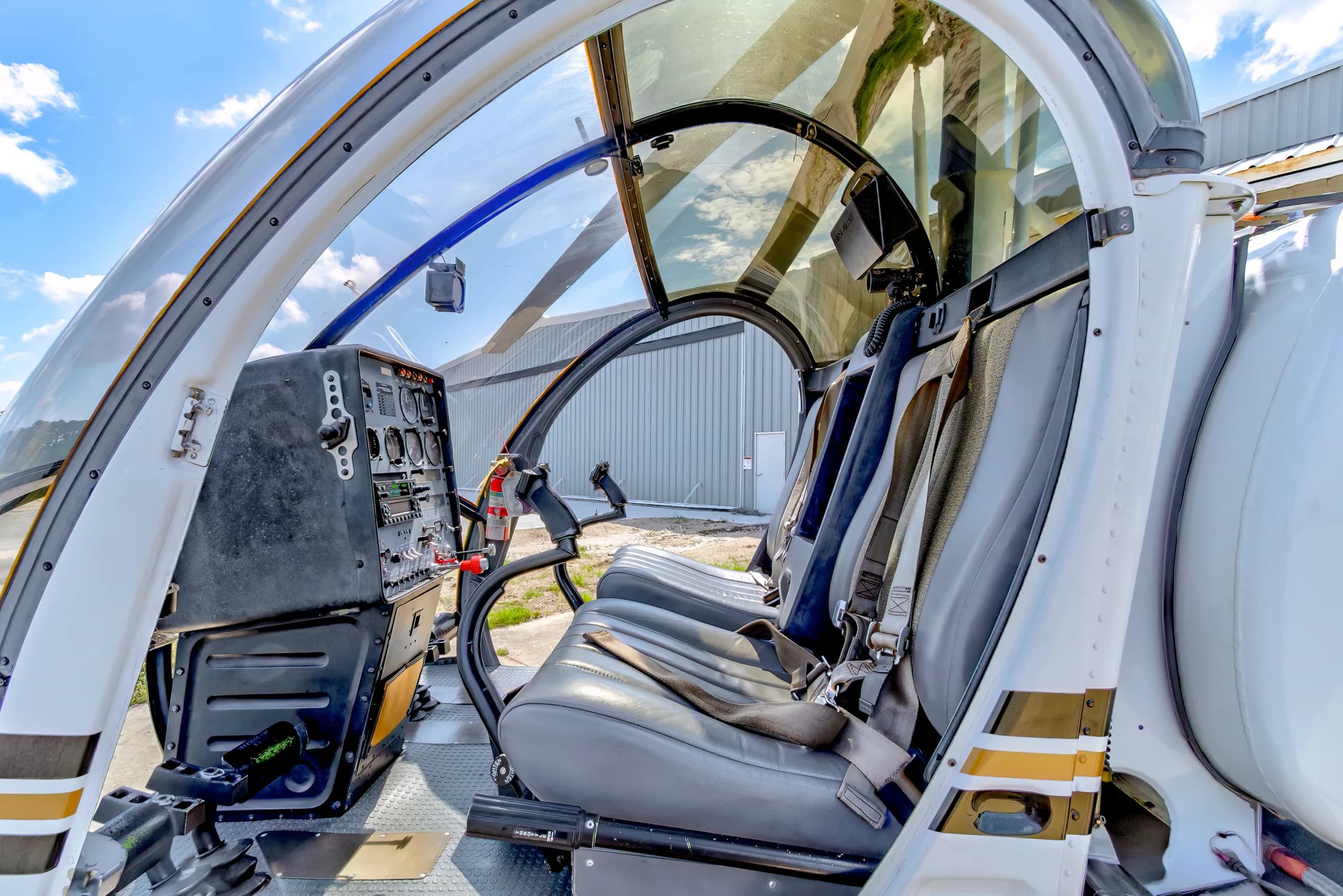 The cockpit and passenger seats of a Schweizer 300CBi helicopter, N124TA, showing the instrument panel and controls.