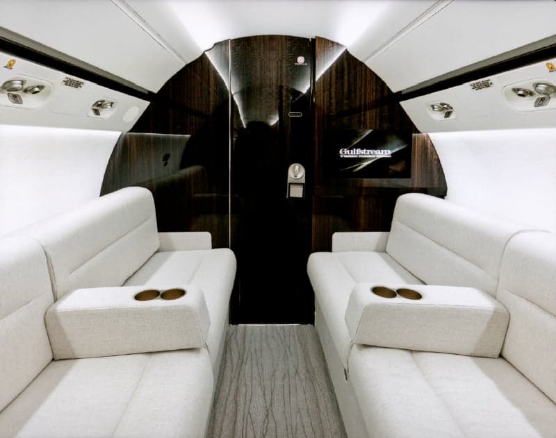 View of the interior cabin with white seats and wood trim.