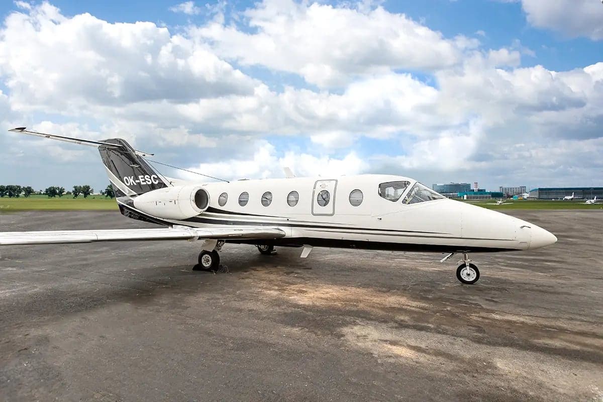 The Nextant 400XT aircraft with registration OK-ESC is parked on the tarmac.
