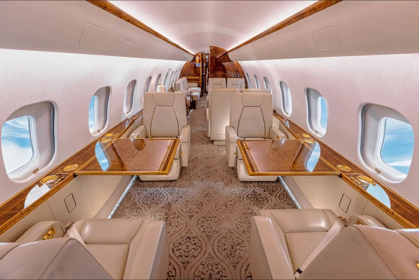 View of the aircraft's interior with cream-colored seats and wood accents.