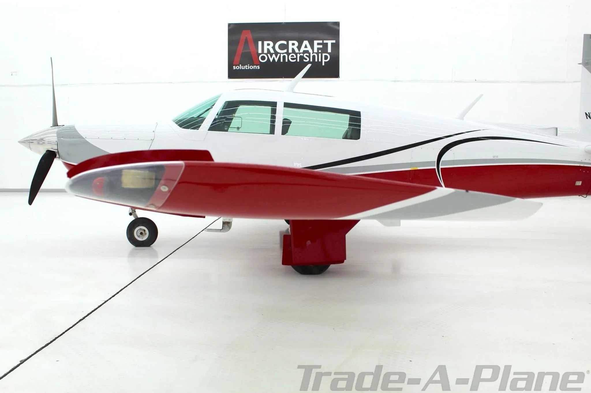 A side view of the Mooney N1039B, highlighting the right wing and paint scheme.