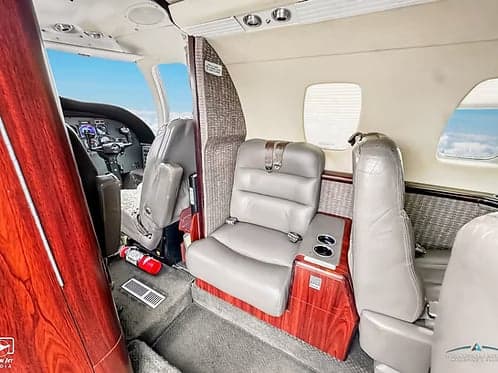 View of the interior cabin of the aircraft, showing leather seats and wood trim.