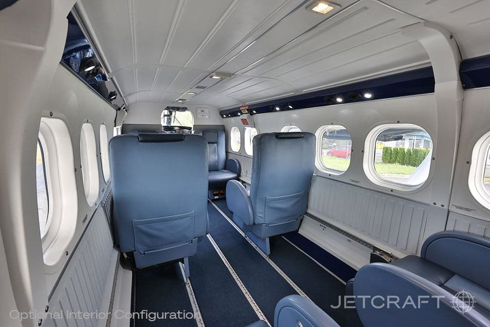 View of the aircraft cabin with blue leather seats and windows.