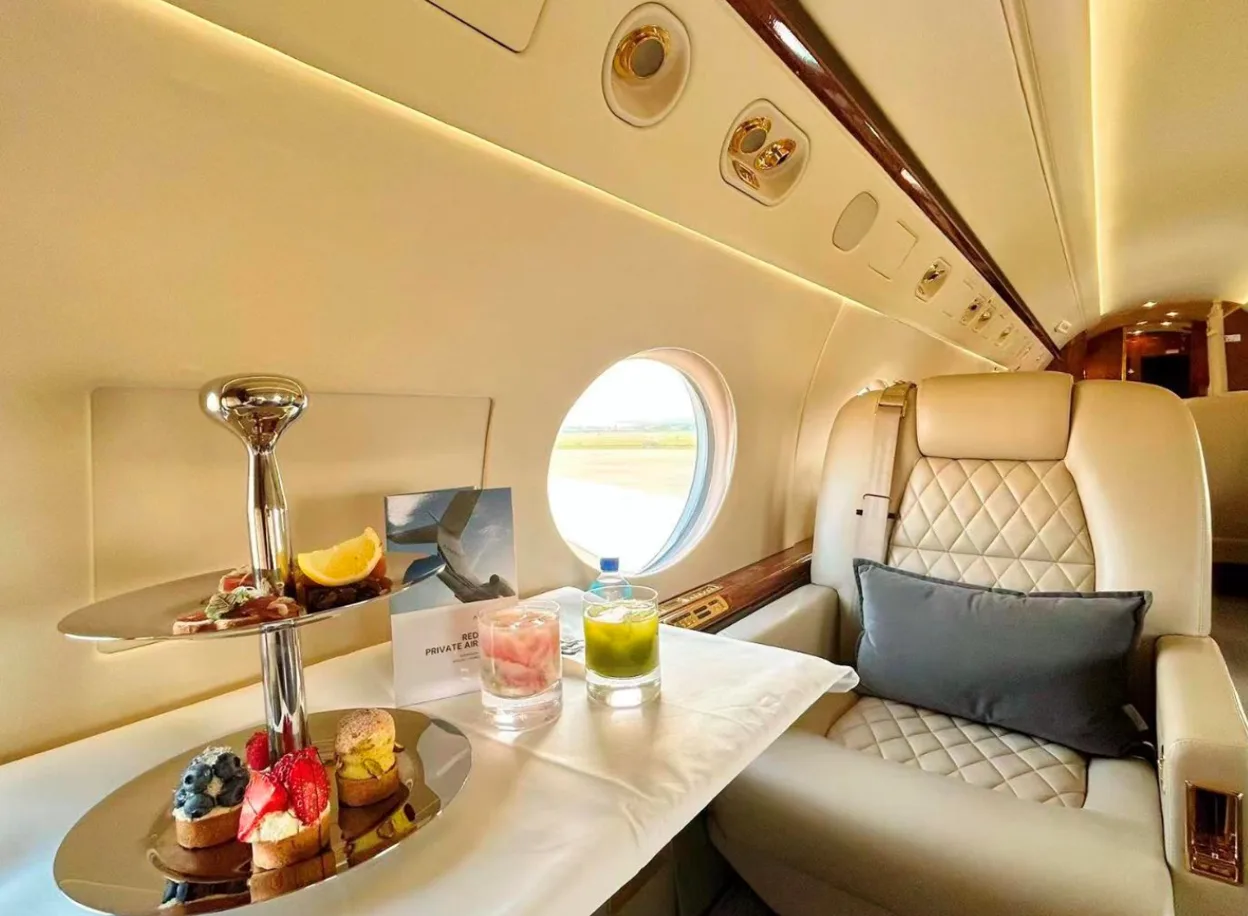 Interior of a private jet with a table set for refreshments.