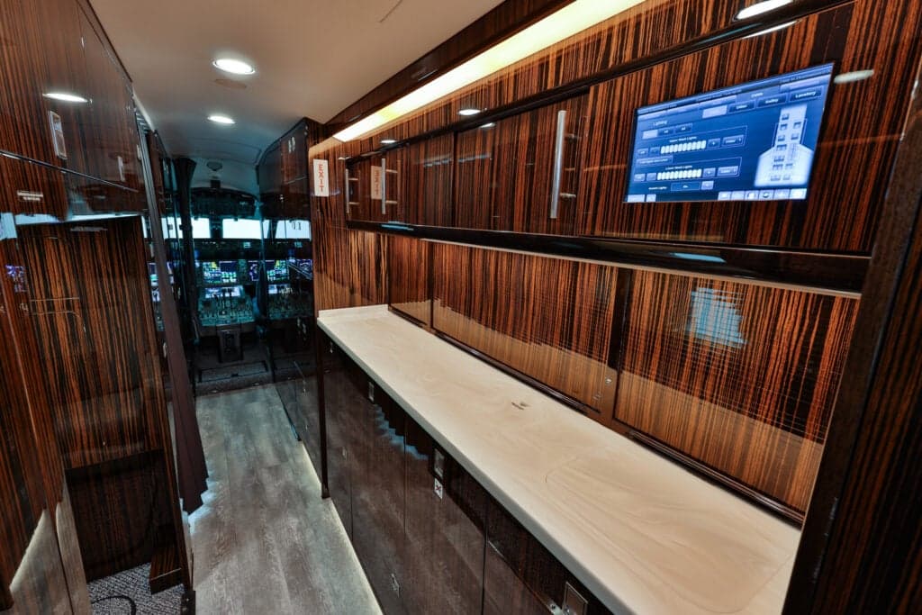 View of the aircraft interior galley area with wood paneling and a countertop.