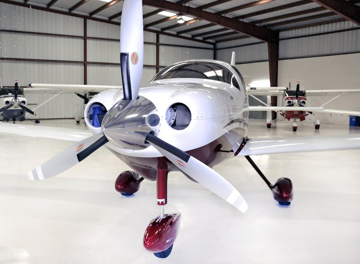 Front view of a Cirrus aircraft in a hangar.