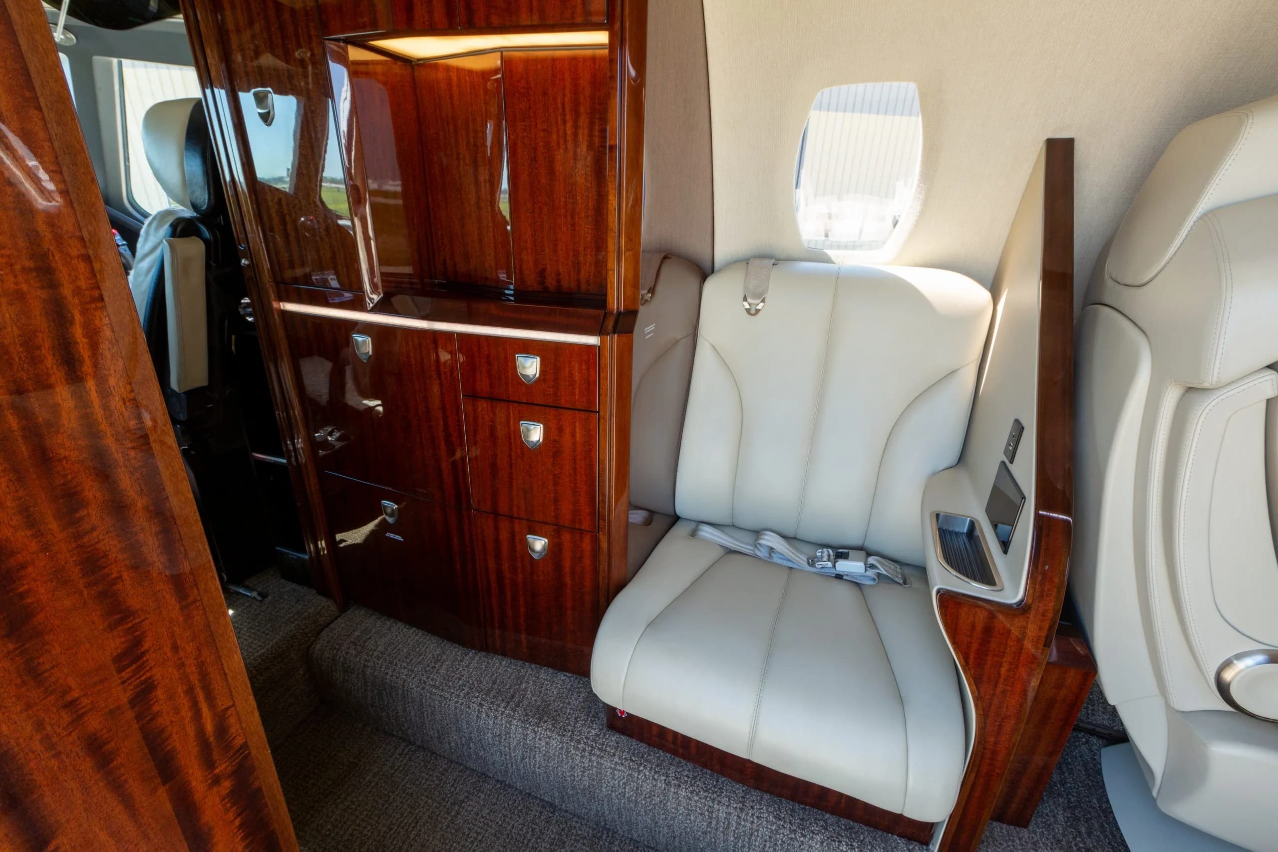 A view of the Citation CJ4 aircraft's interior, showcasing the seating and cabinetry.
