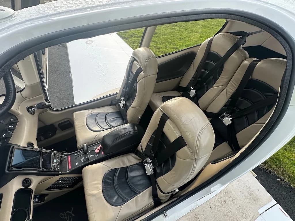 A view into the tan and black leather interior of the Cirrus SR22 cabin, showing both front and rear seats.