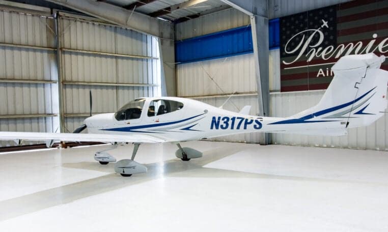 A Diamond DA40 aircraft with registration N317PS is parked in a hangar.