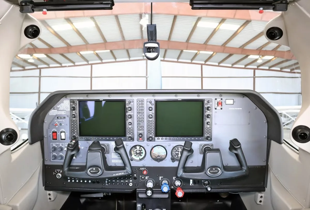 The cockpit of the Cessna Skylane, featuring a modern glass panel with two large displays and control yokes.