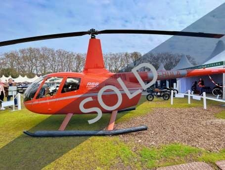 A red Robinson R66 Turbine helicopter on display with a 'SOLD' overlay.