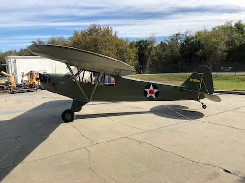 Olive drab aircraft with star insignia on the ramp.