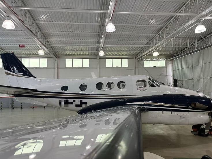Beechcraft King Air 350i in a hangar, with a white and blue paint scheme.