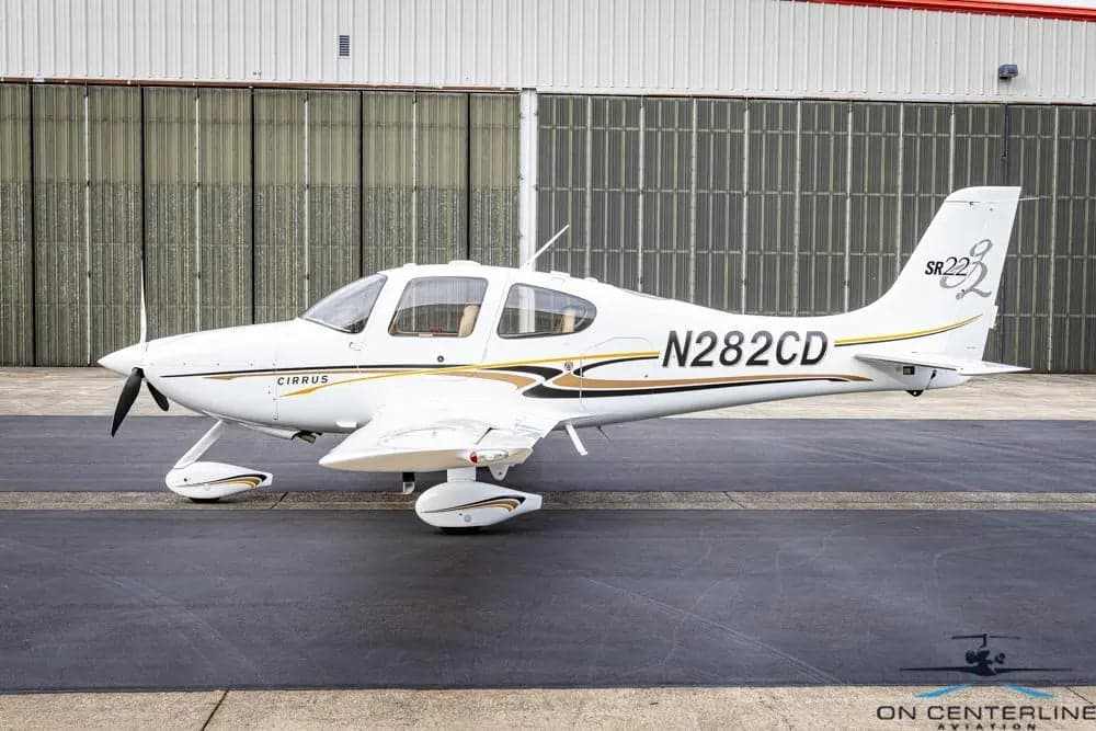 Cirrus SR22T aircraft N282CD parked on the tarmac in front of a hangar.