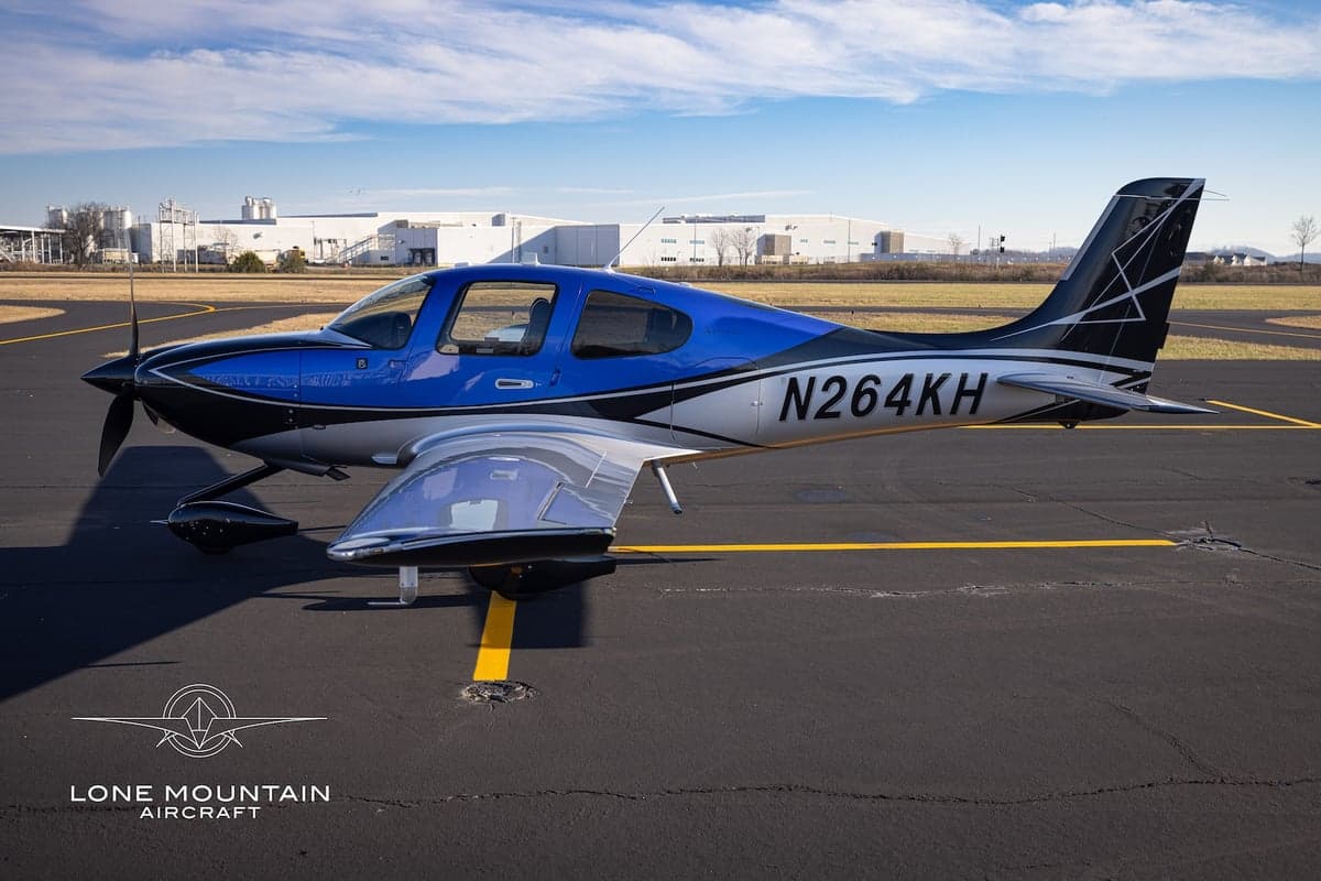 A Cirrus SR22T aircraft with registration N264KH parked on the tarmac.