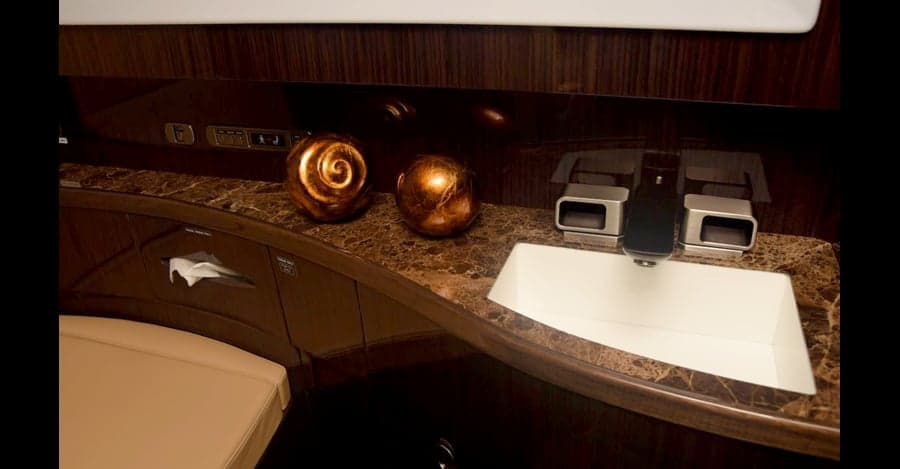 Close-up of the aircraft lavatory with marble countertop and decorative orbs.
