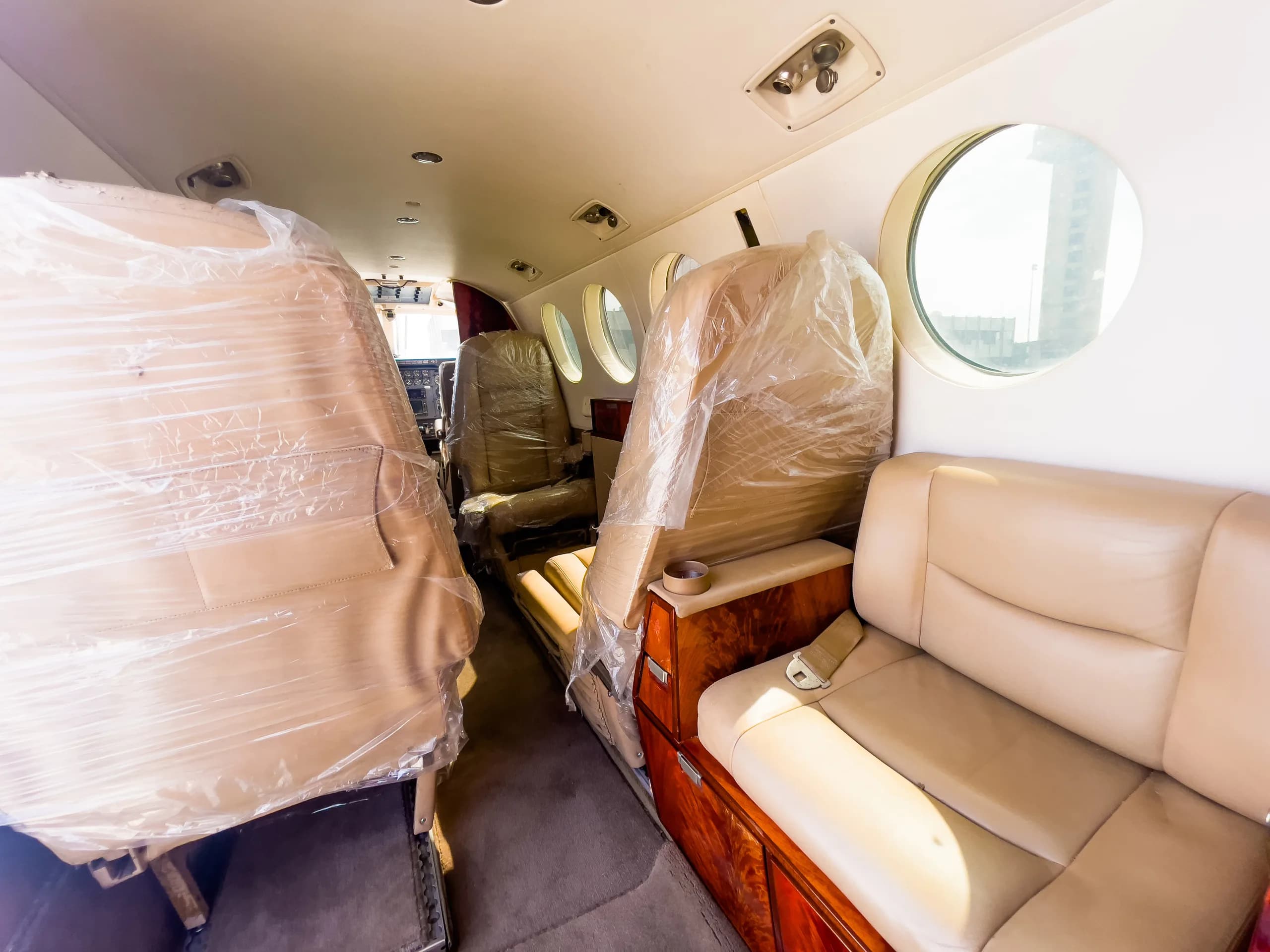 The interior of the aircraft is shown with seats covered in plastic.