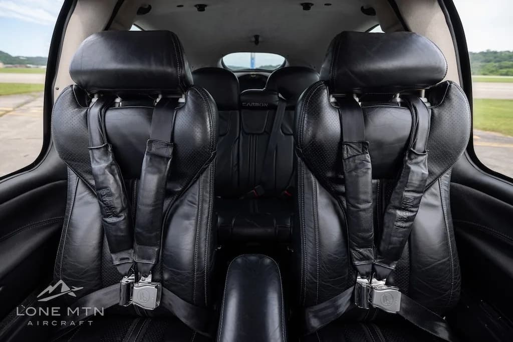 The black leather front passenger seats of the Cirrus SR22T Carbon aircraft cabin, viewed from the rear.