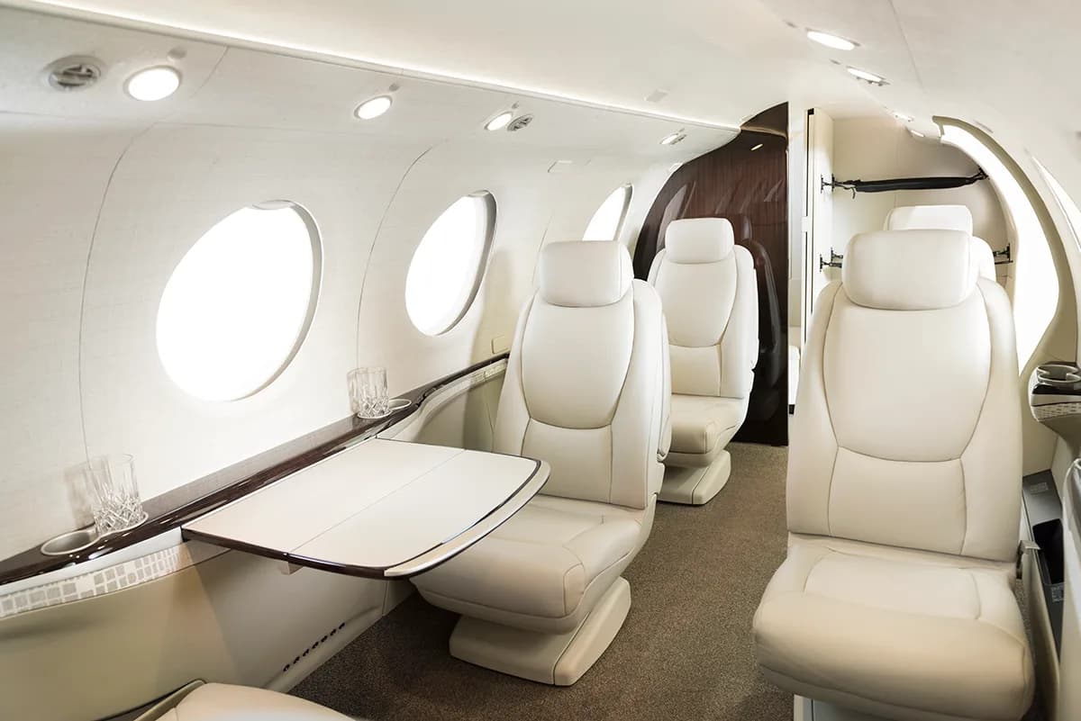 The interior of the Pilatus PC-24 with leather seats and a table.