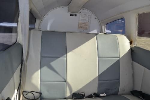 Rear cabin seats of an aircraft with gray and white upholstery.