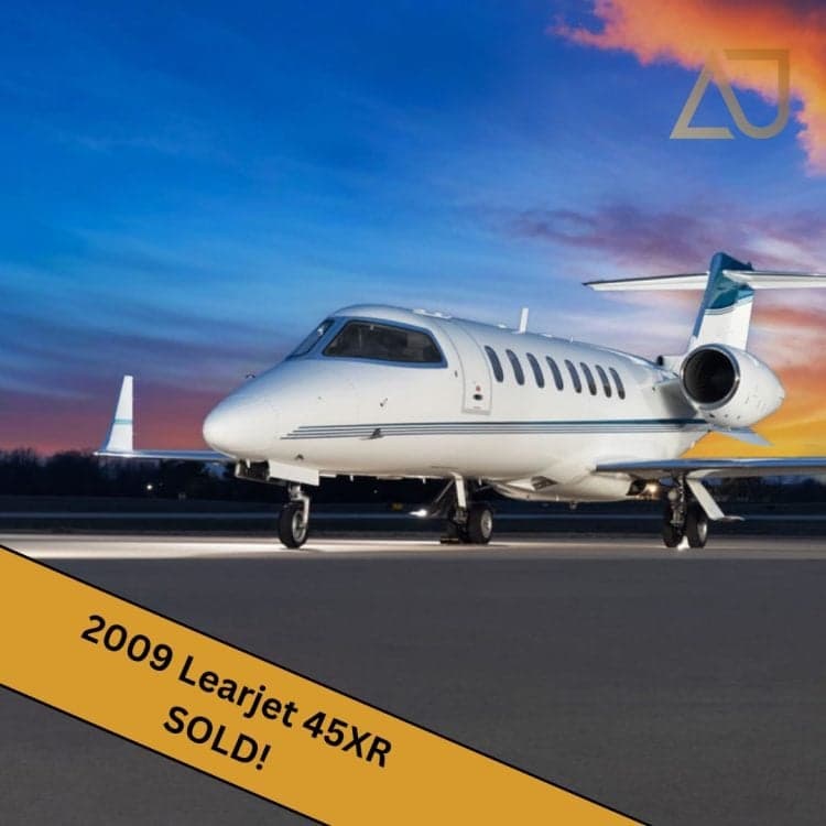 A 2009 Learjet 45XR on the tarmac at sunset, with a 'SOLD!' banner.