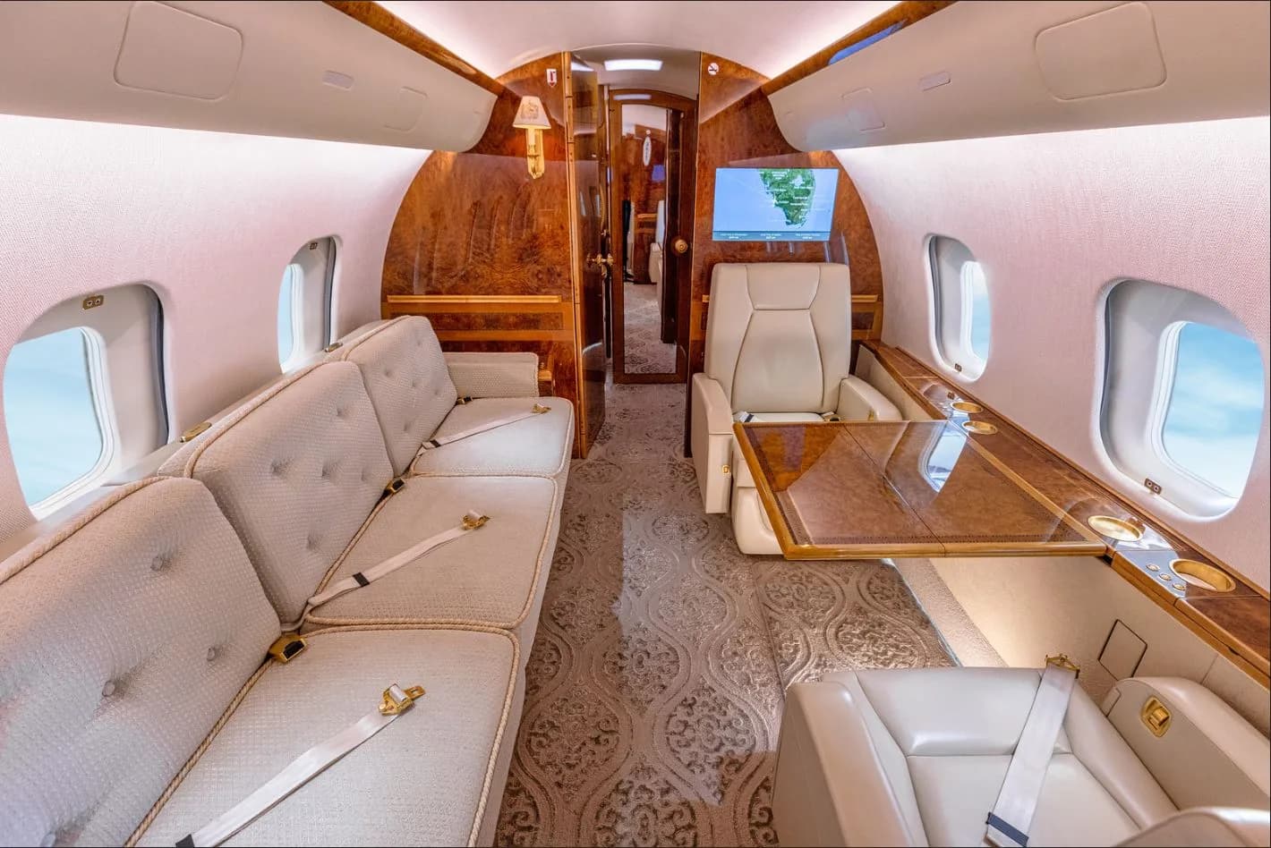 View of the aircraft's interior with cream-colored seats and wood accents.