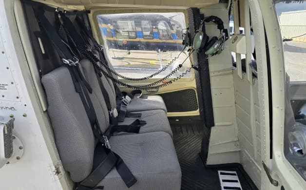 The interior of a helicopter shows the seating arrangement and headsets.