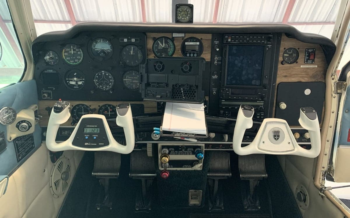 The aircraft's cockpit features a classic instrument panel with dual yokes and modern avionics.