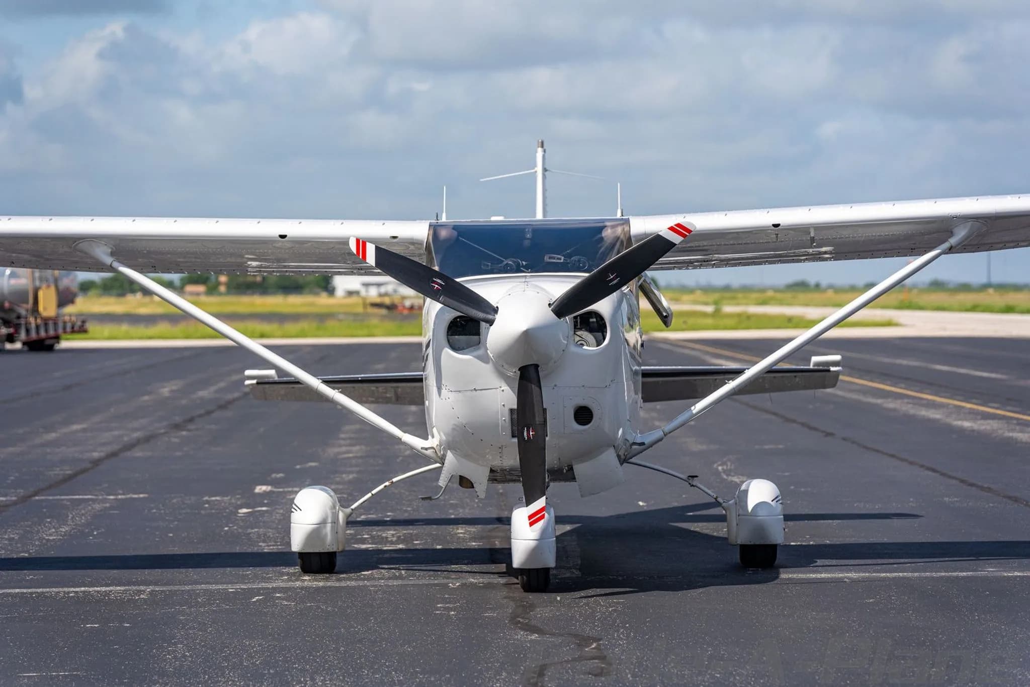 A close-up front view of the propeller and nose of a white Cessna Stationair TC.